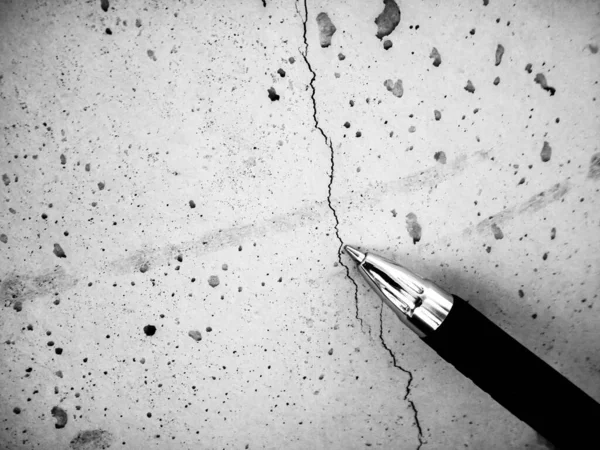 Retakan garis rambut dangkal pada beton segar yang disebabkan oleh penyusutan selama penyembuhan. Pena digunakan untuk referensi. — Stok Foto