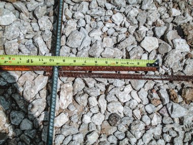 İnşaat alanındaki bir mezura ile inşaat çubuğunu incelemek ve belgelemek