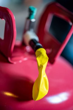 Helyum kutusuna bağlı şişirilebilir bir balonun kenarına seçici odak.