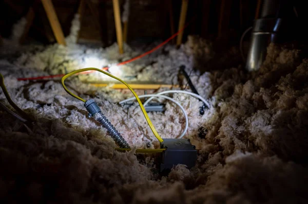 집 다락 방에서 송전용 절연체 위에 놓아둔 전기 전선 과 도관. — 스톡 사진
