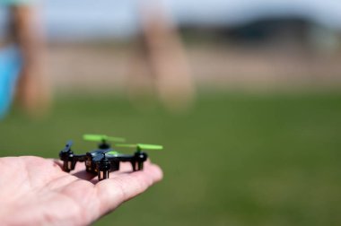 Minyatür oyuncak uzaktan kumandalı İHA bir elden kalkıyor.