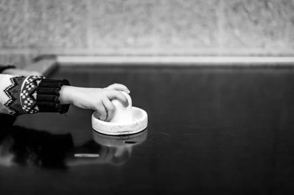 Selectieve focus op een air hockey tafel en een klein kind dat de peddel vasthoudt. — Stockfoto