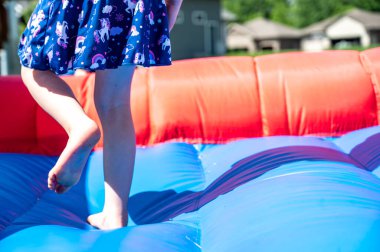 Arka planda bulanık çocukların oynadığı şişme bir evin önsöz kenarına seçici odaklanma