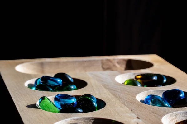 Selektiv fokus på glasperler på et træ mancala bord - Stock-foto