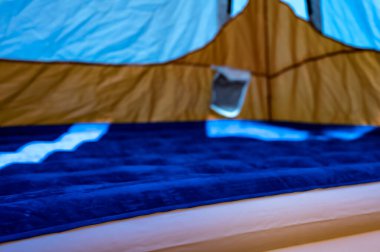 Doldurulan çadırın zeminindeki şişme şişme yatağın seçici odağı. 