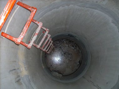 Durgun sulara giden basamakları olan açık beton bir rögar kapağına bakıyorum.