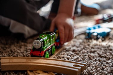 Tiffin, Iowa, ABD - 3.2021: Model Thomas the Train ile oynayan küçük çocuk. Thomas popüler bir demiryolu temalı çocuk oyuncağı.. 