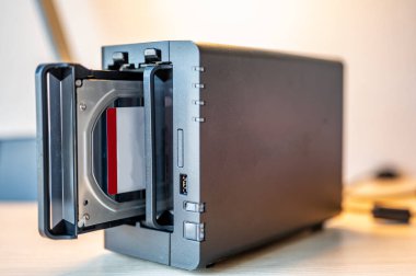 bir ev ofisinde kurulmuş tek bir bölmesi ve uzaktan çalışma fazlalığı olan bir ağ bağlı NAS