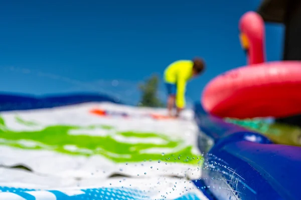 Selective focus on jets of droplets shooting out across a water slide — Foto Stock