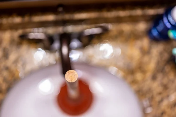 Utilizzando uno stantuffo su un lavabo da bagno tappato con capelli e schiuma in una piscina di acqua stagnante. — Foto Stock