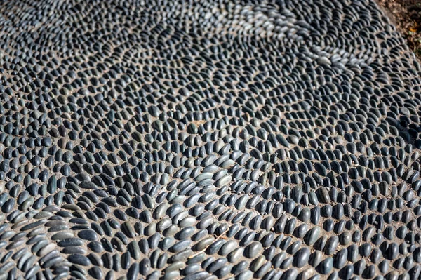 Selective focus on decorative pattern of river rocks laid in garden footpath. — ストック写真
