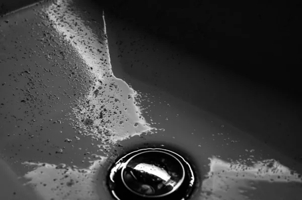 Small pieces of hair left in a bathroom sink after a man finished shaving in the morning. — Foto de Stock