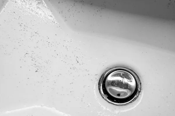 Piccoli pezzi di capelli lasciati in un lavandino del bagno dopo che un uomo ha finito di radersi al mattino. — Foto Stock