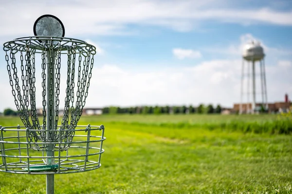 Cadenas de meta de golf de disco balanceándose suavemente en la brisa con un campo verde en el fondo —  Fotos de Stock