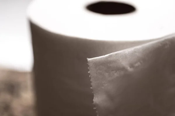 Selektiver Fokus auf das Randblatt einer Rolle Toilettenpapier, wo einzelne Fäden sichtbar sind. — Stockfoto