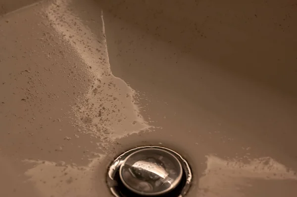 Small pieces of hair left in a bathroom sink after a man finished shaving in the morning. — ストック写真