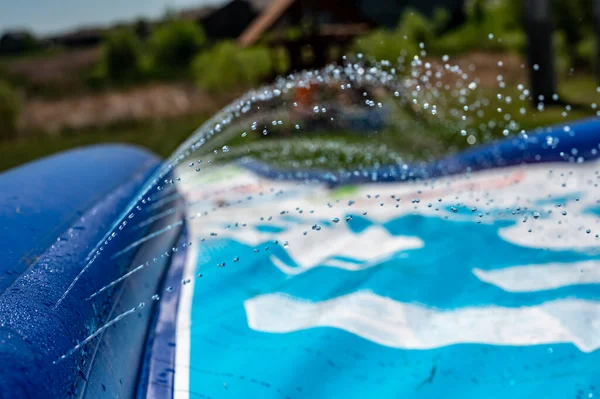 Selektivt fokus på jetstrålar av droppar skjuter ut över en vattenrutschbana — Stockfoto