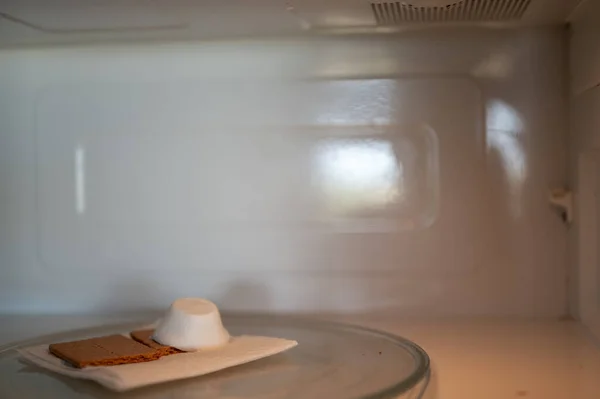 Making a smore with a marshmallow, cracker, and chocolate using a microwave. — 스톡 사진