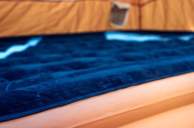 Doldurulan çadırın zeminindeki şişme şişme yatağın seçici odağı. 