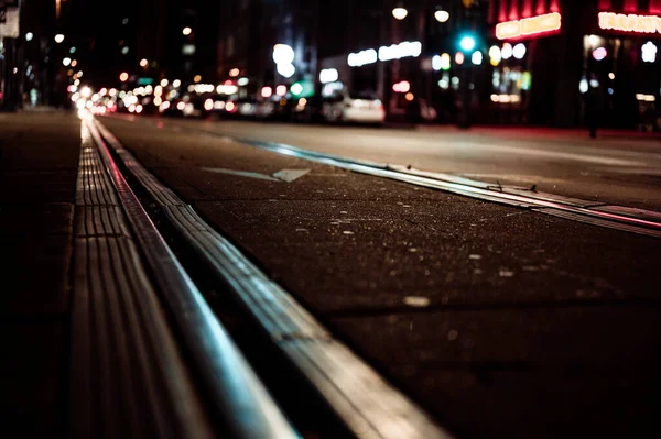 Street level selective focus on trolley rail lines at night in San Diego. High quality photo