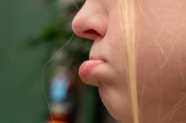 Close-up of a lower lip jutting out on a fussy girl that is pouting. High quality photo