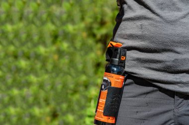 Apgar, Montana, USA - 8.2022 - Can of aerosol bear spray being worn on a hikers belt. . High quality photo