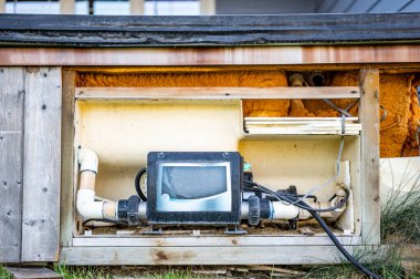 Side of hot tub with panel removed to repair and complete maintenance on the recirculation pump. High quality photo