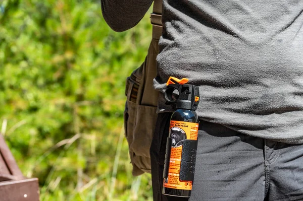 Apgar, Montana, USA - 8.2022 - Can of aerosol bear spray being worn on a hikers belt. . High quality photo