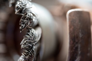 Macro selective focus on the bristle ends of a wire brush wheel on a grinder. High quality photo