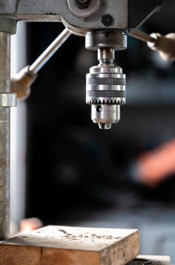 Industrial drill press with wooden board underneath. . High quality photo