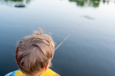 Boy on a fishing with blue water in background . High quality photo