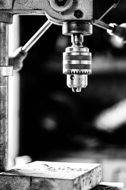 Industrial drill press with wooden board underneath. . High quality photo