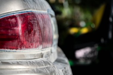 Layer of dust coving the taillight of a car after driving down a gravel road. High quality photo