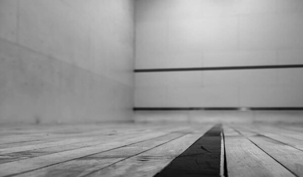 selective focus on a section of wood planking at floor level inside a racquet ball court. High quality photo