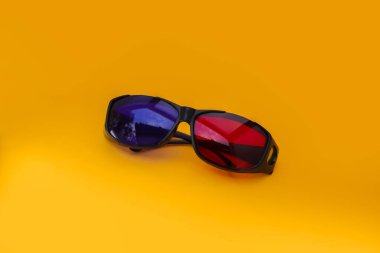 Turuncu arka planda 3 Boyutlu Kırmızı ve Cyan sinema gözlükleri. 3D film gözlükleri görüntüler depoluyor.
