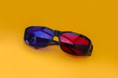 Turuncu arka planda 3 Boyutlu Kırmızı ve Cyan sinema gözlükleri. 3D film gözlükleri görüntüler depoluyor.