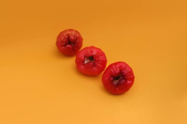 Turuncu arka planda taze gül elma meyvesi. Jambu air Merah (Syzygium aqueum), jambu Semarang (Syzygium samarangense), Jambu Bol veya Malay Apple (Syzygium malaccense) olarak da bilinir.)