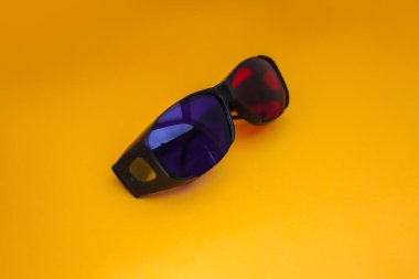 Turuncu arka planda 3 Boyutlu Kırmızı ve Cyan sinema gözlükleri. 3D film gözlükleri görüntüler depoluyor.