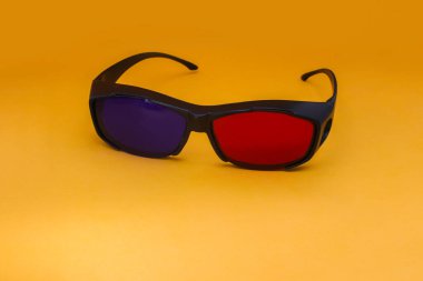 Turuncu arka planda 3 Boyutlu Kırmızı ve Cyan sinema gözlükleri. 3D film gözlükleri görüntüler depoluyor.