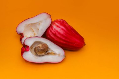 Jambu Bol veya Jambu Jamaika turuncu arka planda ayrıca Malay kırmızı gül elması olarak da bilinir (Syzygium Malaccense).