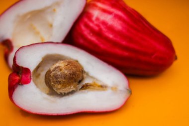 Jambu Bol veya Jambu Jamaika turuncu arka planda ayrıca Malay kırmızı gül elması olarak da bilinir (Syzygium Malaccense).