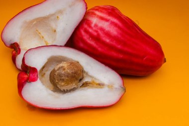 Jambu Bol veya Jambu Jamaika turuncu arka planda ayrıca Malay kırmızı gül elması olarak da bilinir (Syzygium Malaccense).