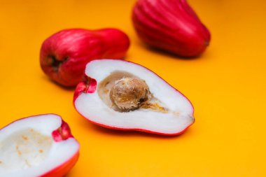 Jambu Bol veya Jambu Jamaika turuncu arka planda ayrıca Malay kırmızı gül elması olarak da bilinir (Syzygium Malaccense).