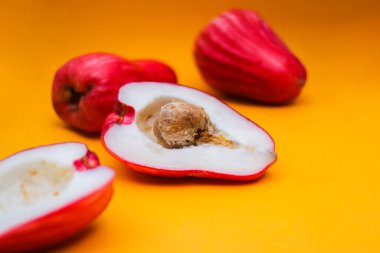 Jambu Bol veya Jambu Jamaika turuncu arka planda ayrıca Malay kırmızı gül elması olarak da bilinir (Syzygium Malaccense).