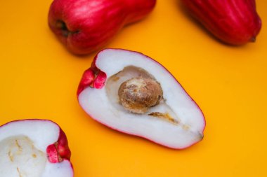 Jambu Bol veya Jambu Jamaika turuncu arka planda ayrıca Malay kırmızı gül elması olarak da bilinir (Syzygium Malaccense).