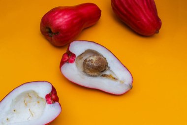 Jambu Bol veya Jambu Jamaika turuncu arka planda ayrıca Malay kırmızı gül elması olarak da bilinir (Syzygium Malaccense).