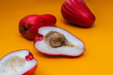 Jambu Bol veya Jambu Jamaika turuncu arka planda ayrıca Malay kırmızı gül elması olarak da bilinir (Syzygium Malaccense).