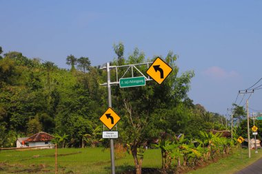 Sukabumi, Batı Java, Endonezya - 14 Haziran 2021: Turuncu zemin üzerinde sola dönüş uyarısı ve yeşil yol işareti Loji Palangpang Sukabumi, Endonezya.