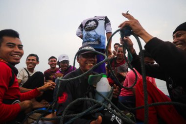 Sukabumi, Endonezya - 14 Haziran 2021: Endonezya 'nın Pelabuhan Ratu Sukabumi Körfezi' nde balıkçı teknelerinde gülen bir grup mutlu Endonezyalı balıkçı