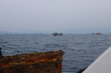 Sukabumi, Endonezya - 14 Haziran 2021: Endonezya 'nın Endonezya bölgesindeki Pelabuhan Ratu Sukabumi' de balık yakalamak için denize açılan Endonezya kırmızı-beyaz bayrağıyla bir grup balıkçı.